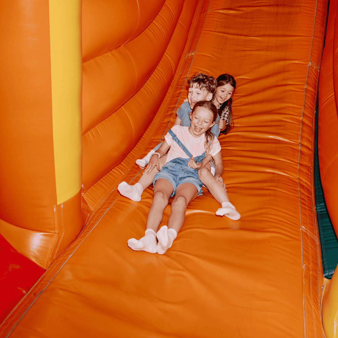 Kids going down the slide at a backyard birthday party