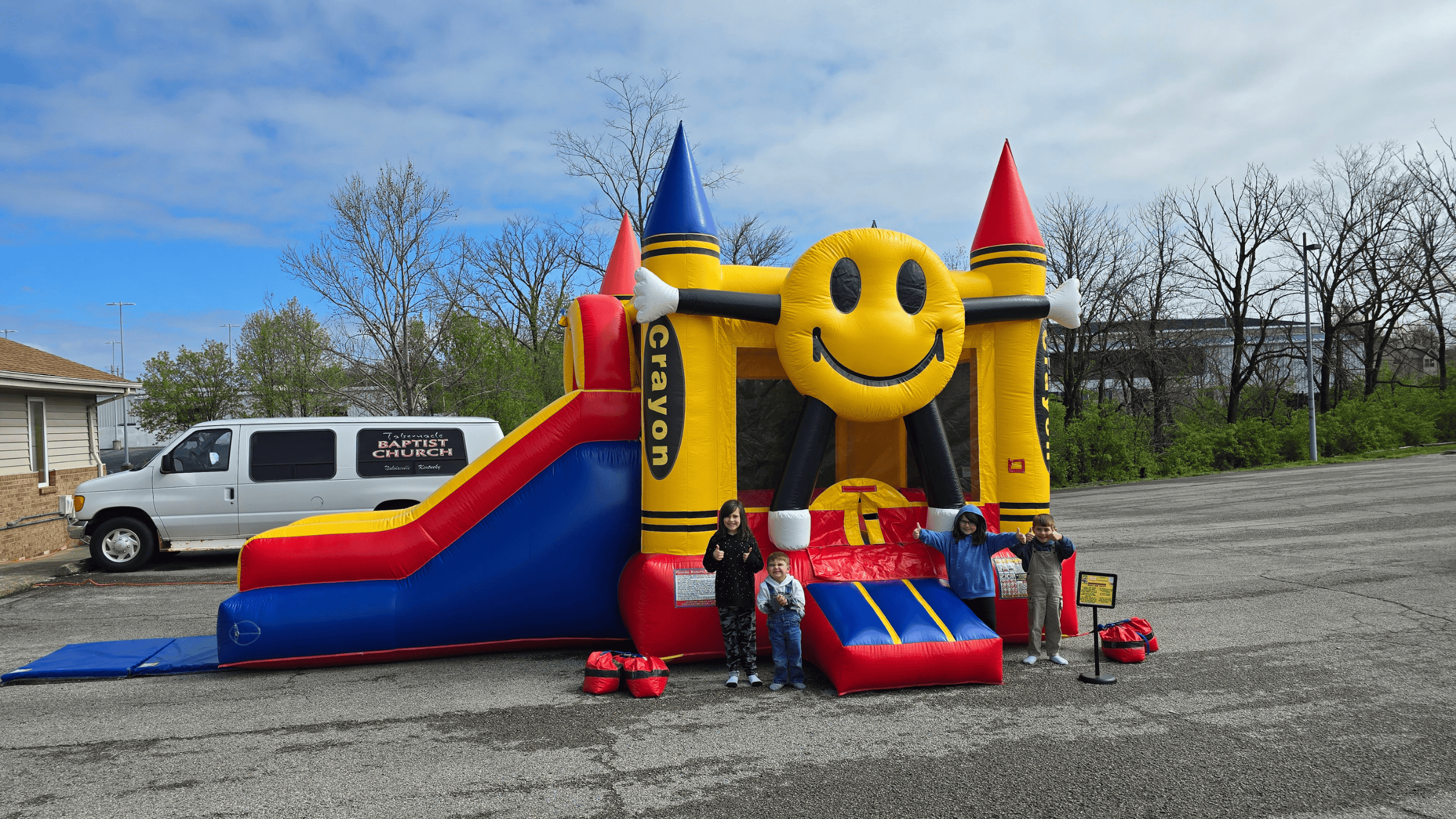 Happy Crayon bounce house with smiling kids at a church event in Nicholasville KY