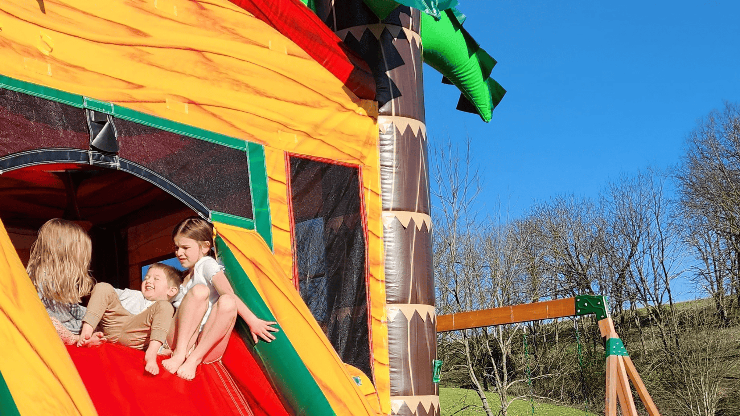 Kids sitting on the Palm Paradise bounce house at a Central Kentucky event