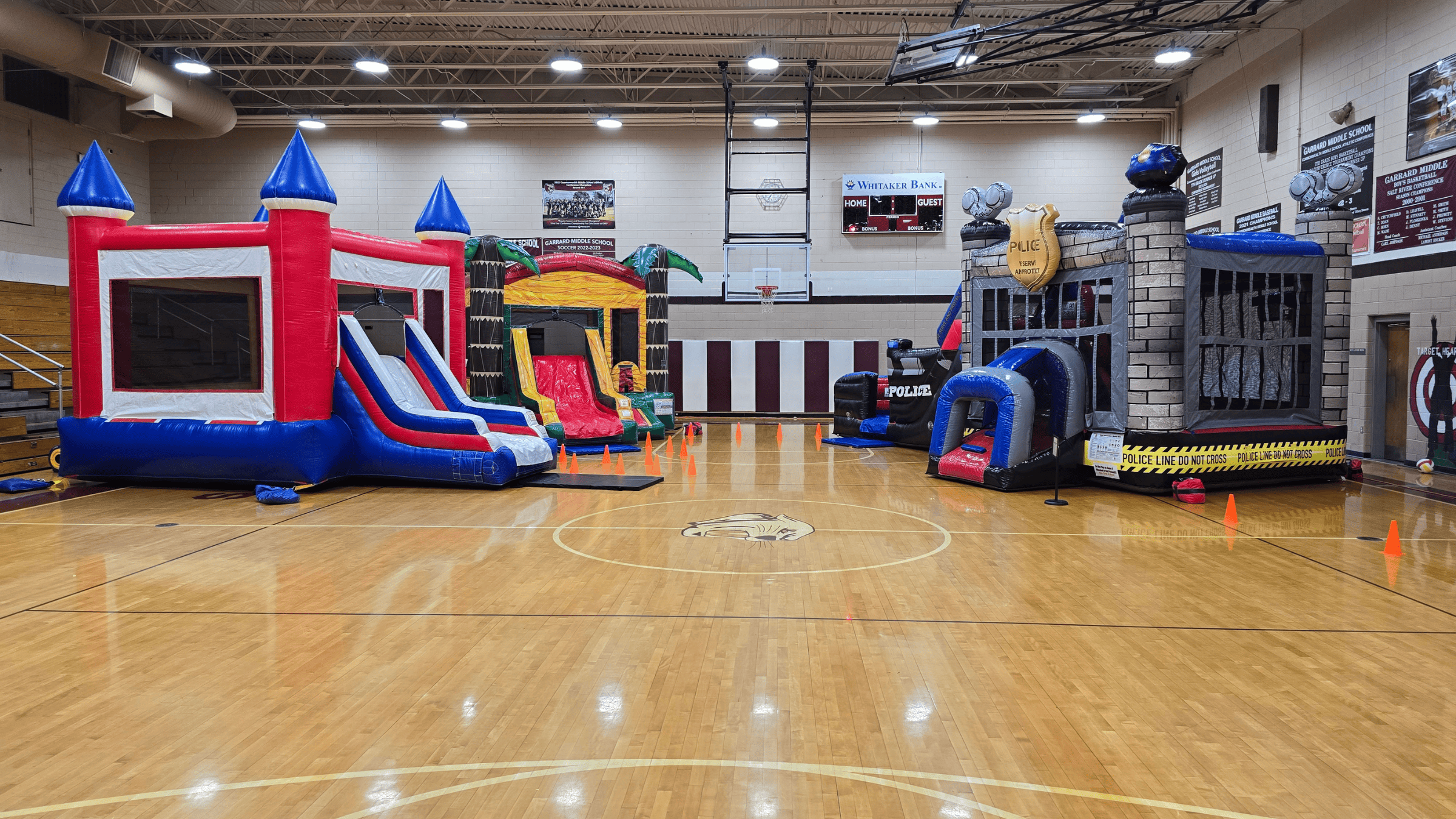 Police Cruiser, USA and Palm Paradise bounce houses set up at a school event