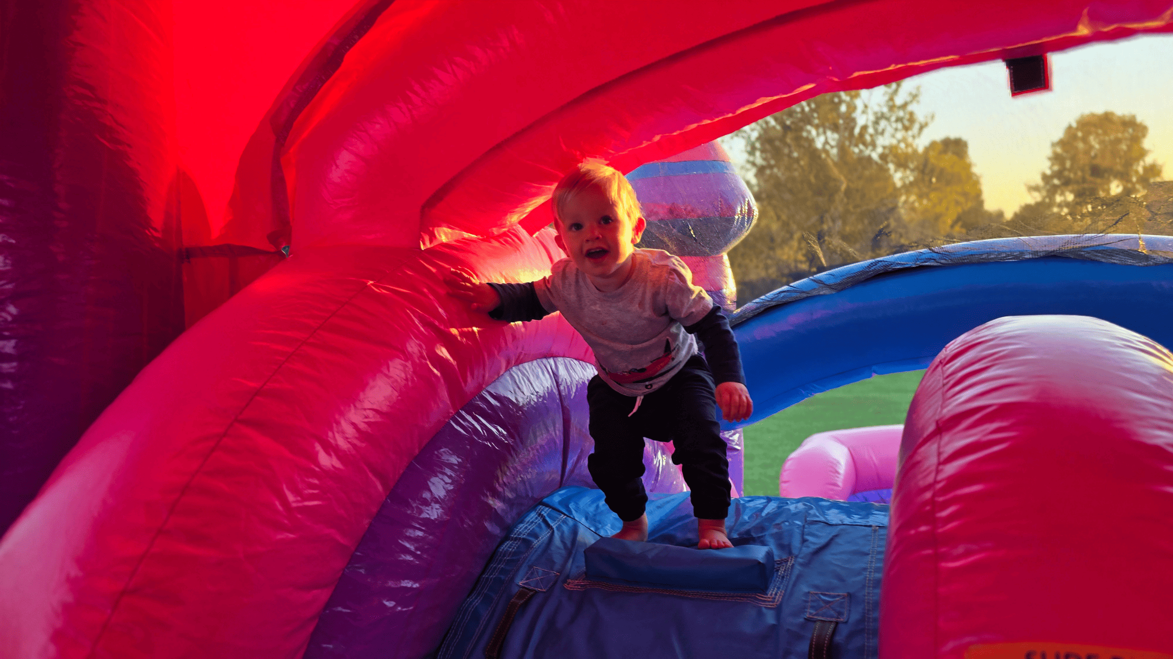 Boy getting big air jumping inside the Purplish inflatable jump house rental in Central Kentucky