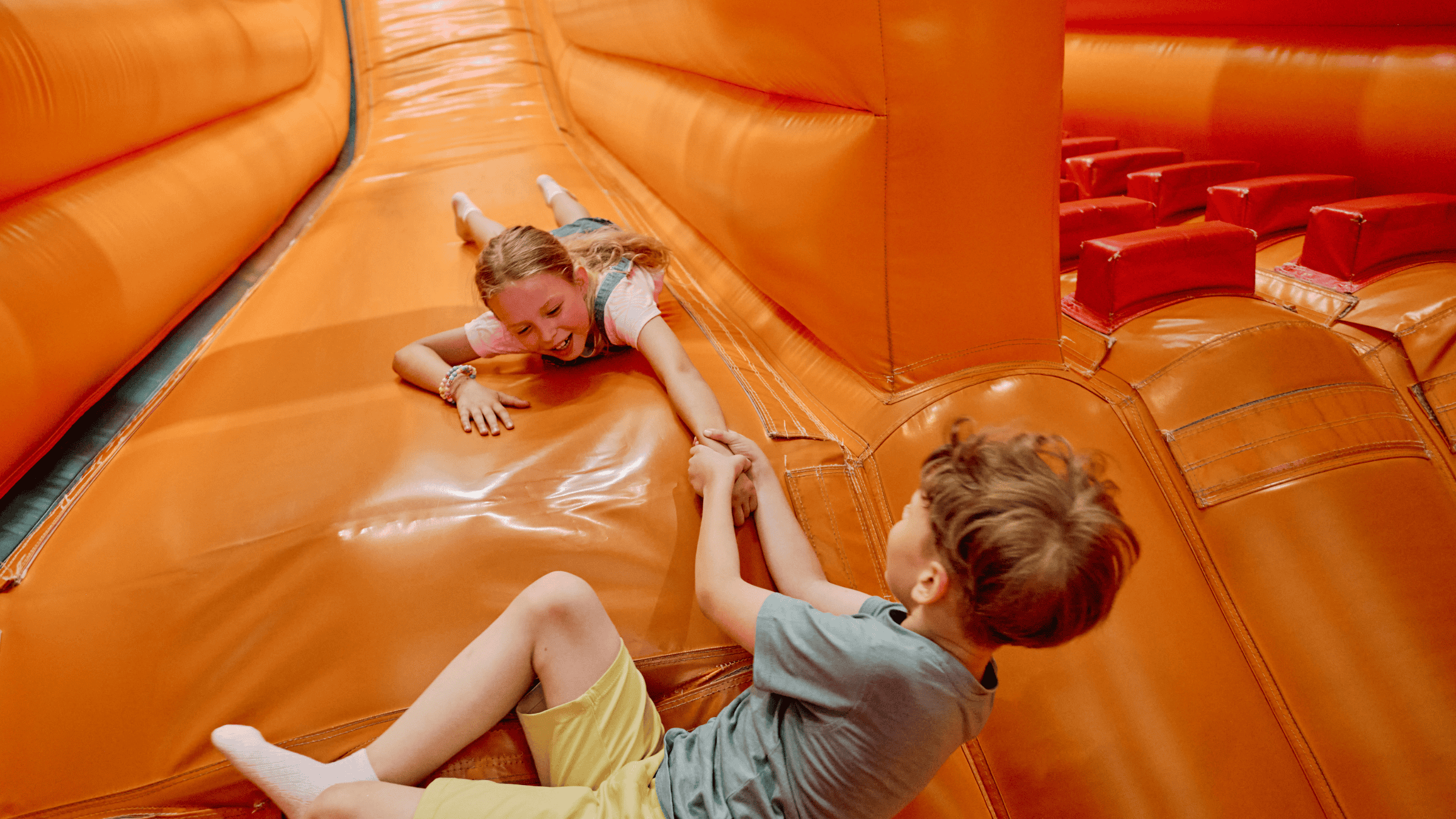 Kids going down an inflatable water slide rental together in Central Kentucky