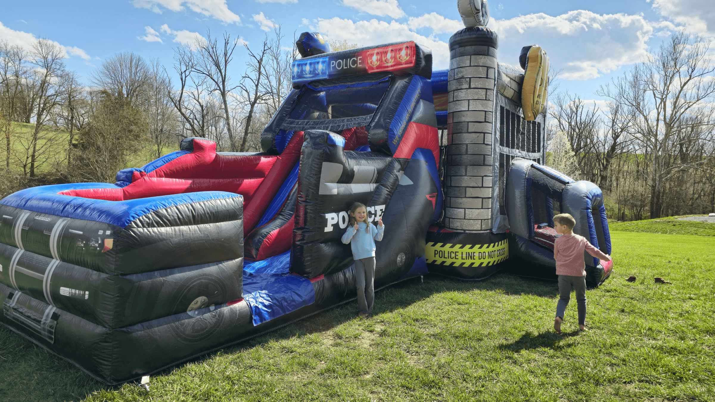Kids in front of the Police Cruiser inflatable bounce house rental from Backyard Responders Central Kentucky